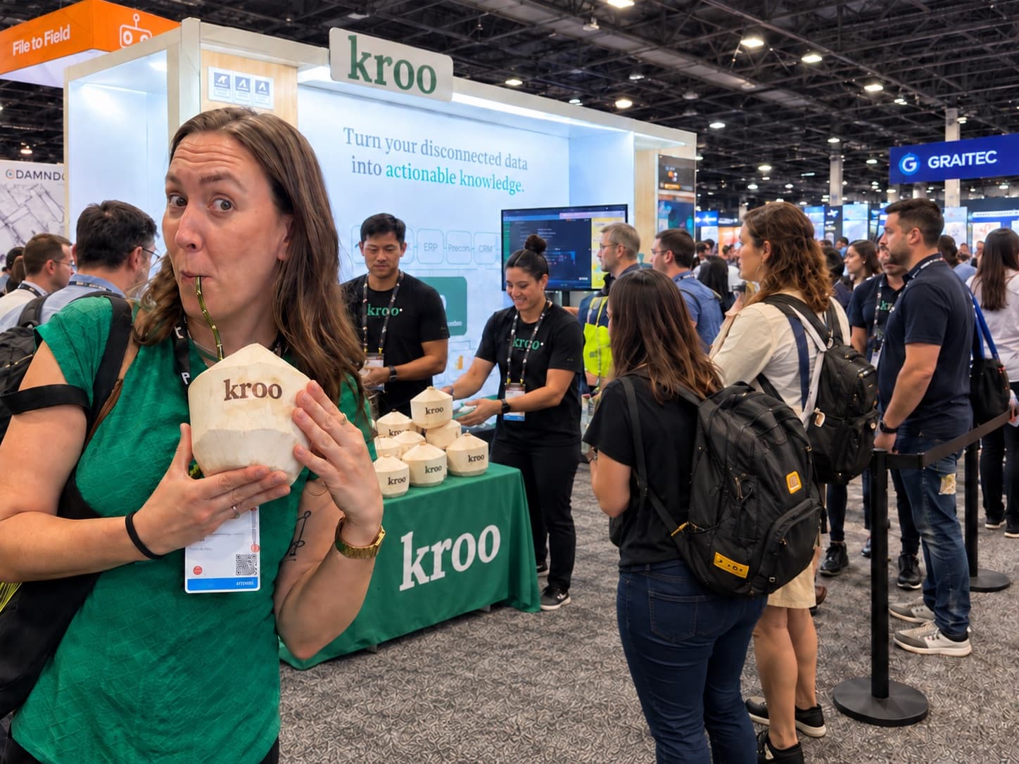 A conference attendee sipping from a young coconut branded with a company logo